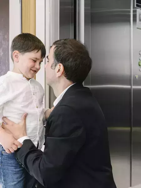 Padre e hijo en el rellano junto al ascensor